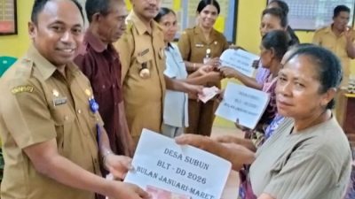 Plh Camat Insana Barat saat Ireneus Abi menyerahkan uang BLT pada warga Desa Subun.